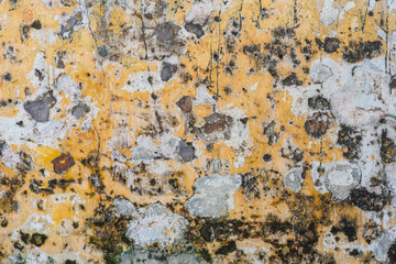 Weathered and scratched old yellow wall. Typical texture of an old wall of the ancient yellow city of Hoi An, Vietnam.