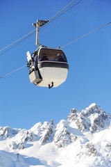 Ski gondola in winter with mountain background 