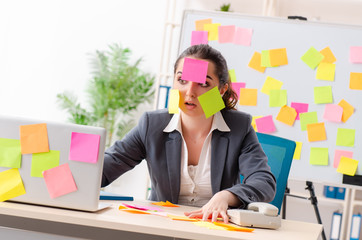 Young female employee in conflicting priorities concept 
