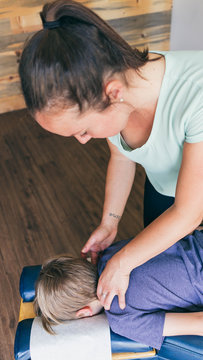 Female chiropractor adjusting Young Kid