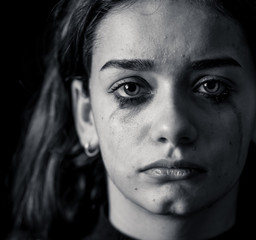 Sad young girl crying and suffering harassment online. Cyberbullying and dangers of internet.