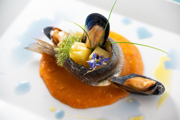 Turbante di spigola con patate e cozze su bisque di gamberi