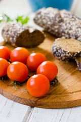 Bunch of cherry tomatoes over wooden board.