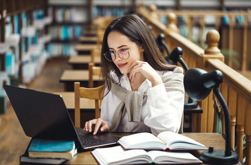 Brunette woman using laptop computer for startup project, researching information online