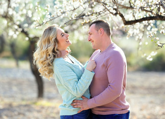 Fototapeta premium Beautiful couple in the flowering gardens in the spring