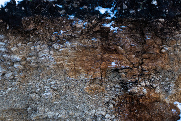 Soil cut-sandstone, stones, clay, sand structure and layers. slice of sand with layers of different structures. Layers of sedimentary sandstone rock.