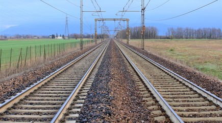 railway in the field two strips of rail and wires above them