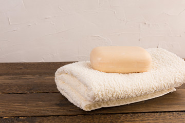 Obraz na płótnie Canvas a piece of soap with towel on wooden table