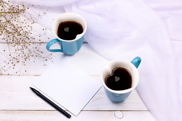 Heart shaped coffee cups with blank paper and pen. Love and romantic relationship concept mockup.