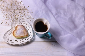 Hart shaped coffee cup, pancake and plate on white wooden background. Love and romantic concept mockup.