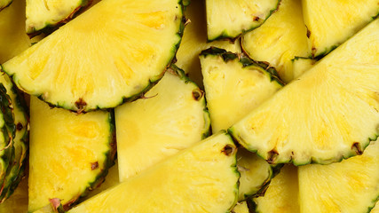 Pineapple juicy yellow slices background. Top view.