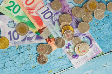 Canadian dollars and coins on the wooden background