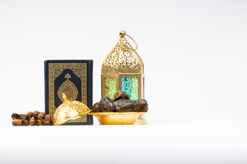 Lantern, Dates, Koran and Rosary on white background with selective focus and crop fragment. Ramadan, Religion and Copy space concept