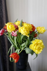 beautiful bouquet of spring flowers yellow and red tulips in a black vase