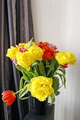 beautiful bouquet of spring flowers yellow and red tulips in a black vase