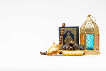 Lantern, Dates, Koran and Rosary on white background with selective focus and crop fragment. Ramadan, Religion and Copy space concept