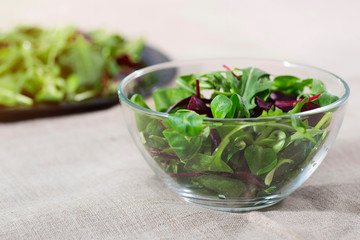 A salad from spinach and greens in a g, a close-up in a glass bowl.