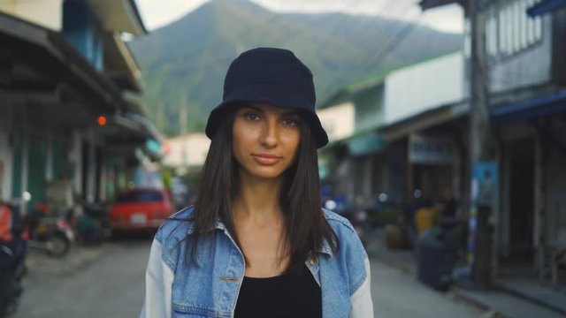 Beautiful woman wearing black hat walking through city streets living urban happy lifestyle