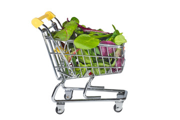 A shopping cart with fresh salad at the white isolated background. Shopping.