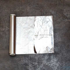 foil for cooking. lies on the table. it is deployed and a bit wrinkled.