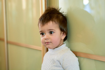 Closeup indoor portrait of a baby boy with naughty hair. The various emotions of a child are...