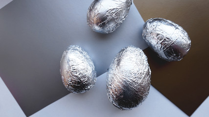 Eggs in foil on silver background. Easter concept banner