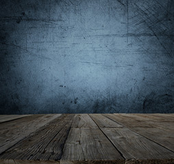 Old wooden floor boards and empty blue concrete wall