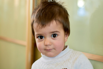 Closeup indoor portrait of a baby boy with naughty hair. The various emotions of a child are...