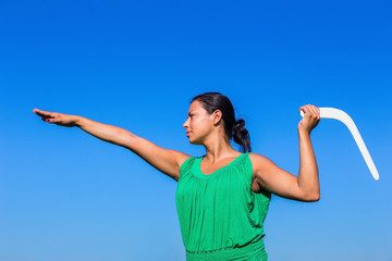 Colombian woman throws boomerang in blue sky - obrazy, fototapety, plakaty