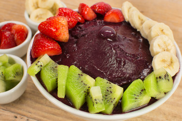 Brazilian acai and fruits in wood background close