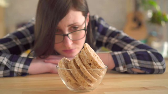 Concept of gluten intolerance. A young girl looks at the loaves that cause allergies