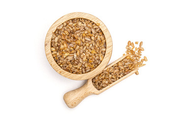 Lot of whole raw bulgur grains in a scoop with wooden bowl flatlay isolated on white background