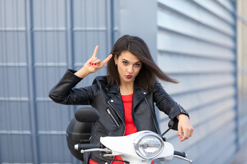 Fototapeta na wymiar Beautiful young girl in town with white motorbike and black leather jacket