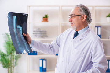 Naklejka na ściany i meble Aged male doctor radiologist in the clinic 