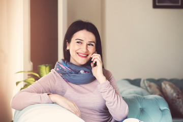 Girl looking on window land line and talking phone in the living room at home 