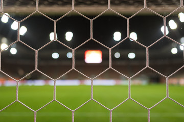 Fototapeta premium Net of the football goal with stadium in the background