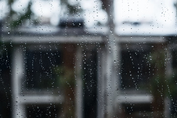 Raindrops on the glass on the background of the house - 254509178