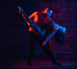 Professional dancers perform an incendiary dance in a dark room with illumination