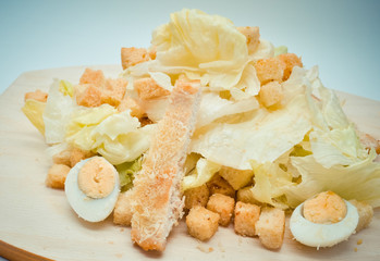fresh homemade Caesar salad with quail eggs and Parmesan cheese grated on a fine grater.
