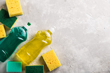 flat lay composition with cleaning supplies for dish washing and space for text on grey background