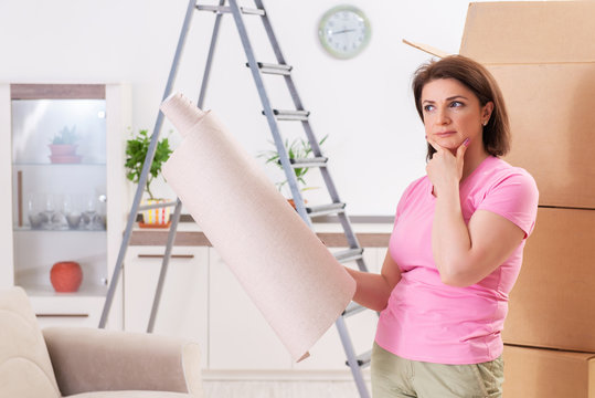 Woman chosing wallpaper for flat renewal 