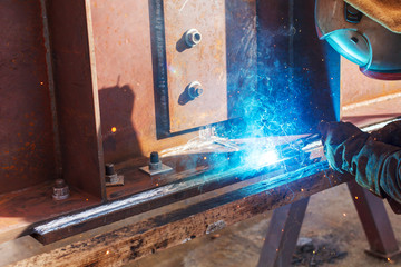 Worker welding in a factory. Welding on an industrial plant