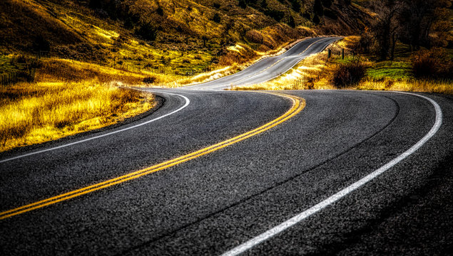 asphalt road between grasses during daytime
