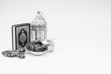 Kuala Lumpur, Malaysia - February 28, 2019 : Lantern, Dates, Koran and Rosary on white background with selective focus and crop fragment. Ramadan, Religion and Copy space concept. Black and White