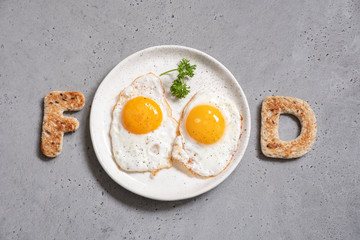 Word food written with toast letters fried eggs