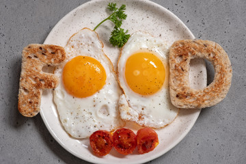 Word food written with toast letters fried eggs