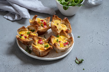 Egg muffins with peppers in a toast cup for breakfast brunch.