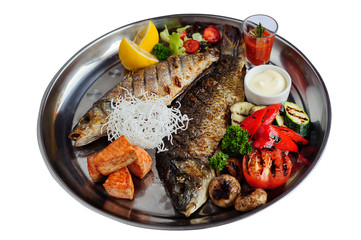 Grilled fish with vegetables and sauce on plate