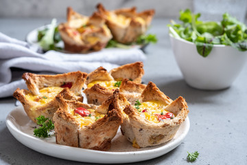 Egg muffins with peppers in a toast cup for breakfast brunch.