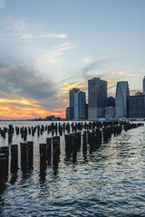 Lower Manhattan skyline scenic view from Brooklyn Bridge Park in New York City during sunset, East River side